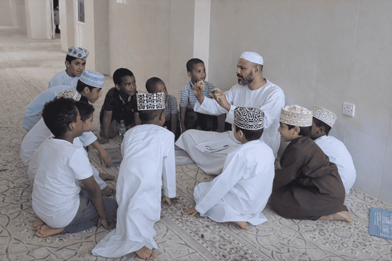 A tutor teaching a circle of young students the Qur'an in person